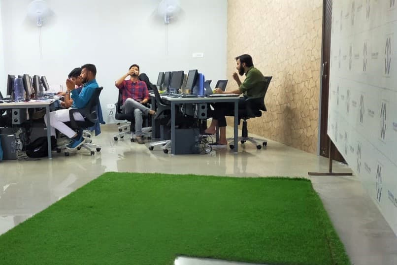 Members at workstations on the open floor